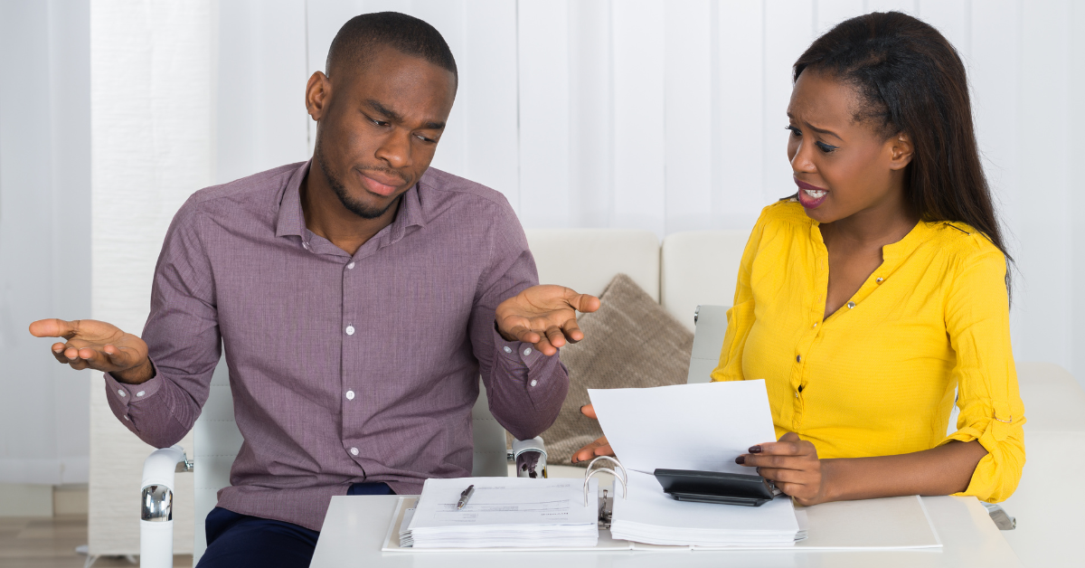 a black man and woman couple arguing over bills