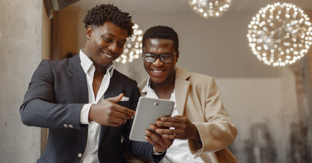 two black men friends share a tablet