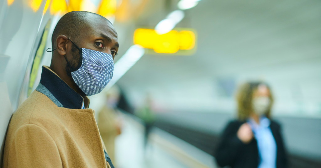 a man wearing a mask in a subway