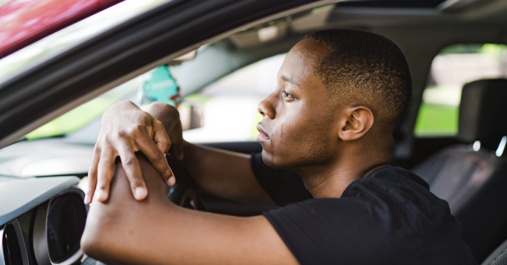 man crying in a car